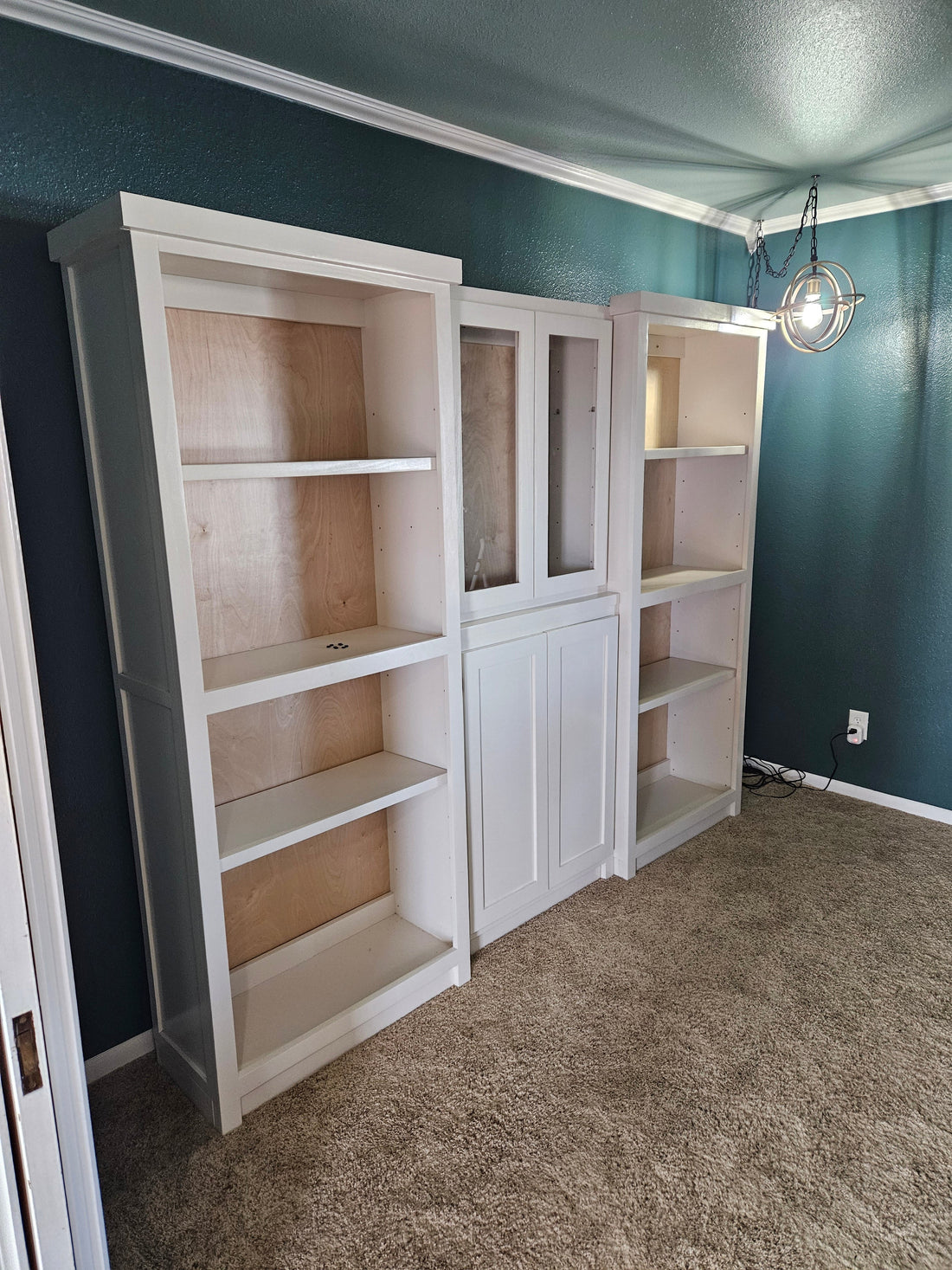 Bespoke 90-inch handcrafted library system with Shaker doors and glass inserts, custom built by The Stockton Mill in Attica, KS