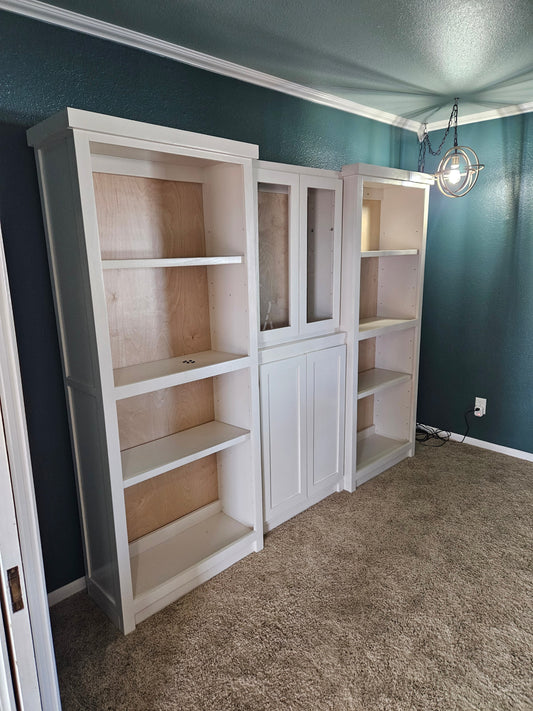 Bespoke 90-inch handcrafted library system with Shaker doors and glass inserts, custom built by The Stockton Mill in Attica, KS